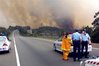 Police set up a road block near a bushfire south of Sydney. 
Climate change is likely to lead to higher rates of some infectious and 
respiratory diseases as well as more injuries from storms and bushfires,
 a report by Australian doctors have warned.(AFP/File/David Hancock)