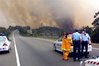 Police set up a road block near a bushfire south of Sydney. 
Climate change is likely to lead to higher rates of some infectious and 
respiratory diseases as well as more injuries from storms and bushfires,
 a report by Australian doctors have warned.(AFP/File/David Hancock)